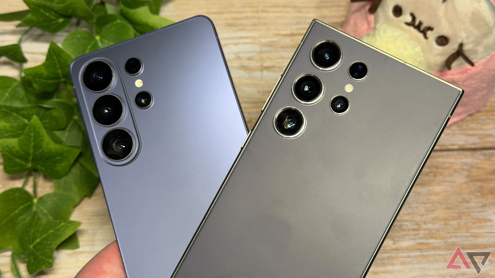 Două telefoane Samsung cu camere multiple, pe un fundal natural.