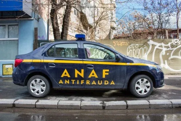 Mașină ANAF parcată pe o stradă dintr-un oraș, cu graffiti pe ziduri.