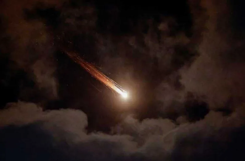 Lumină strălucitoare pe cer în timpul unui atac aerian nocturn.