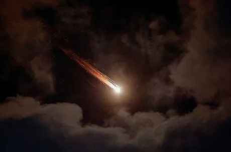 Lumină strălucitoare pe cer în timpul unui atac aerian nocturn.