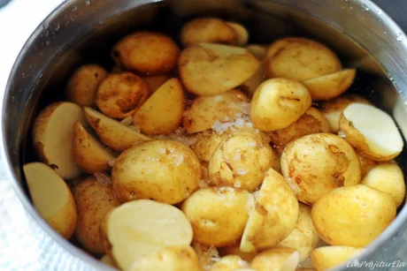 Cartofi noi românești fierți, pregătiți pentru servire, cu sare.