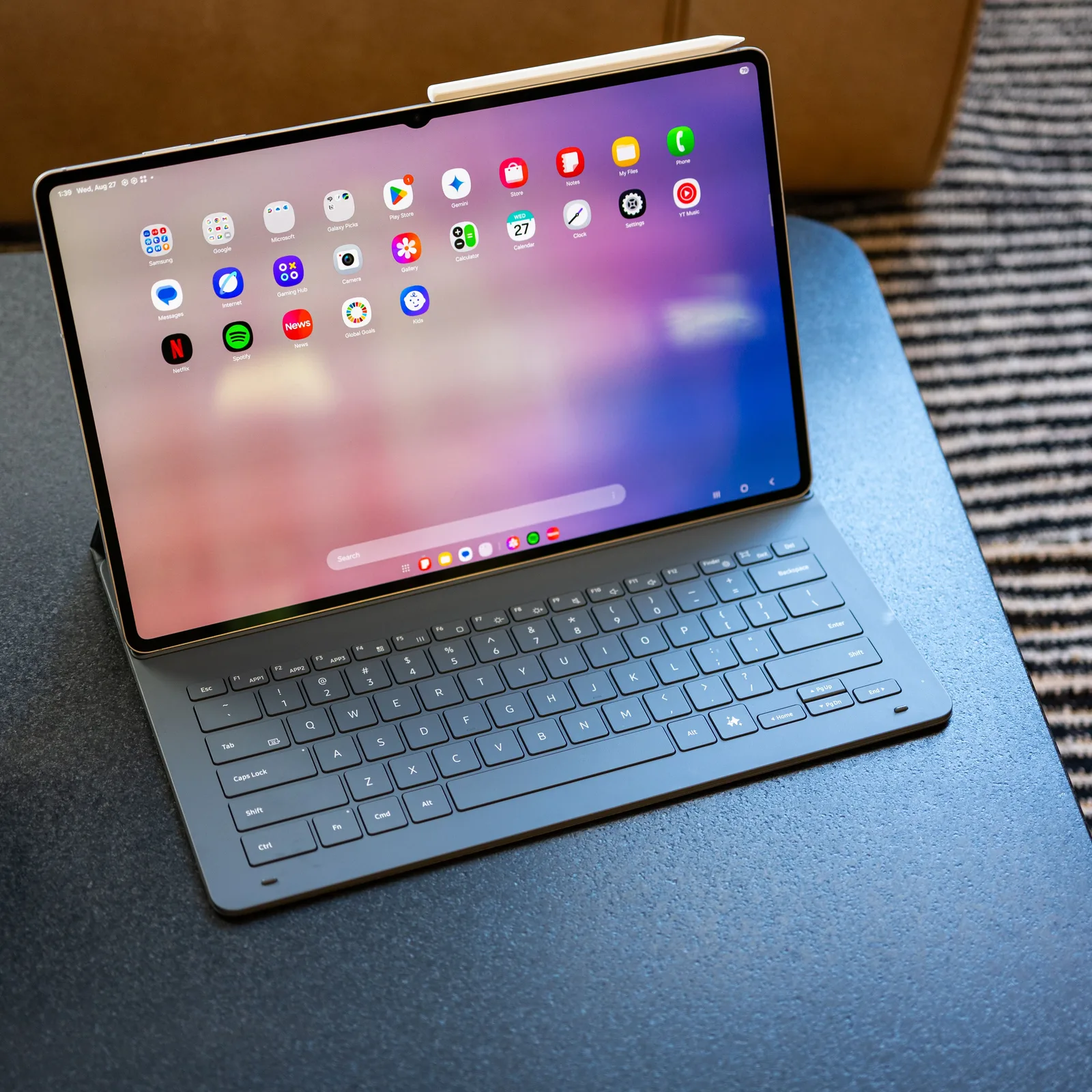 Tableta Galaxy Tab S12+ pe un birou, cu tastatură atașată.
