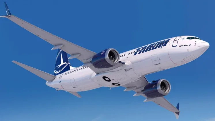 Avion TAROM zburând pe un fundal albastru senin.