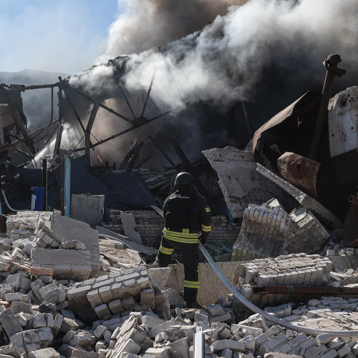 Un pompier inspectează ruinele unei clădiri distruse de atacuri.