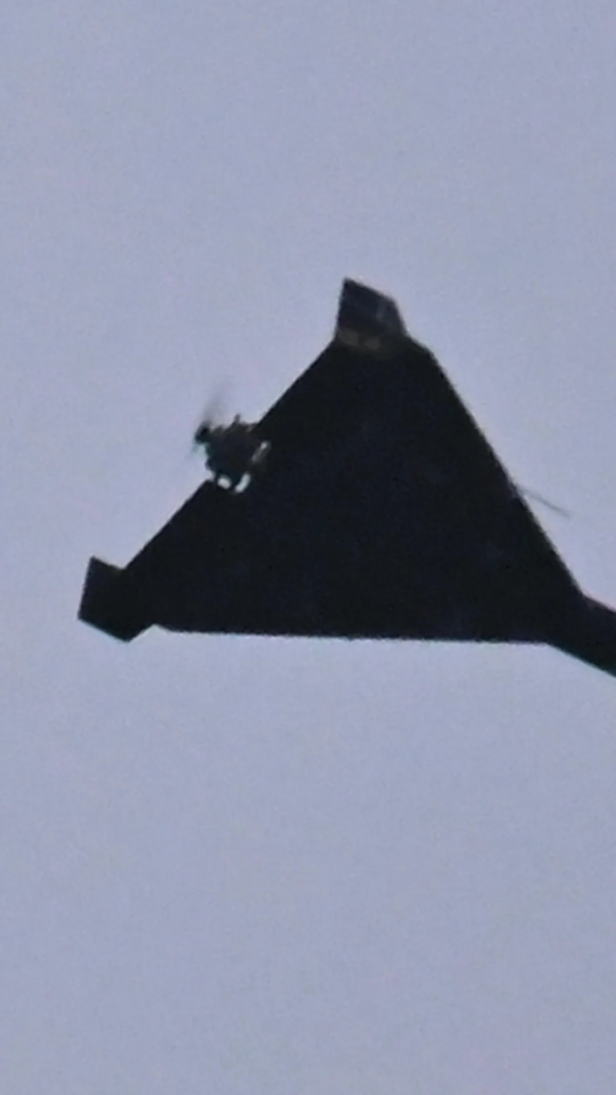 O dronă de tip Shahed zboară pe cerul înnorat.