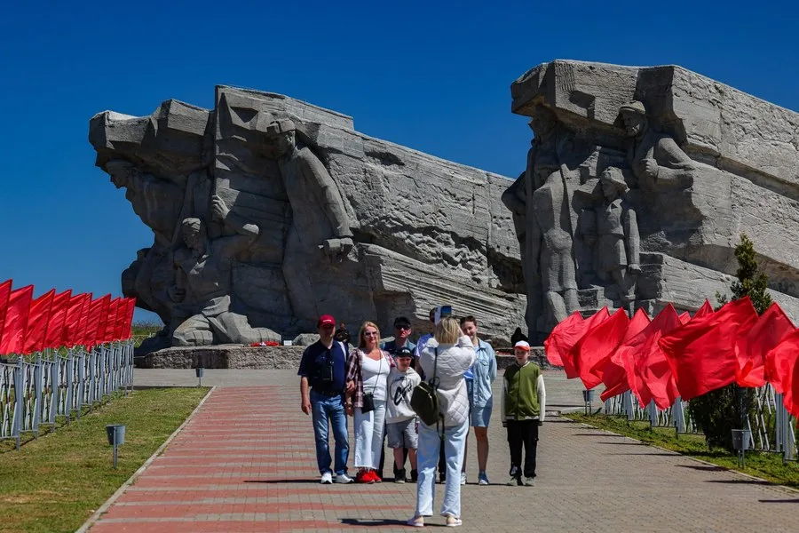Grup de oameni vizitând un monument impresionant în aer liber.