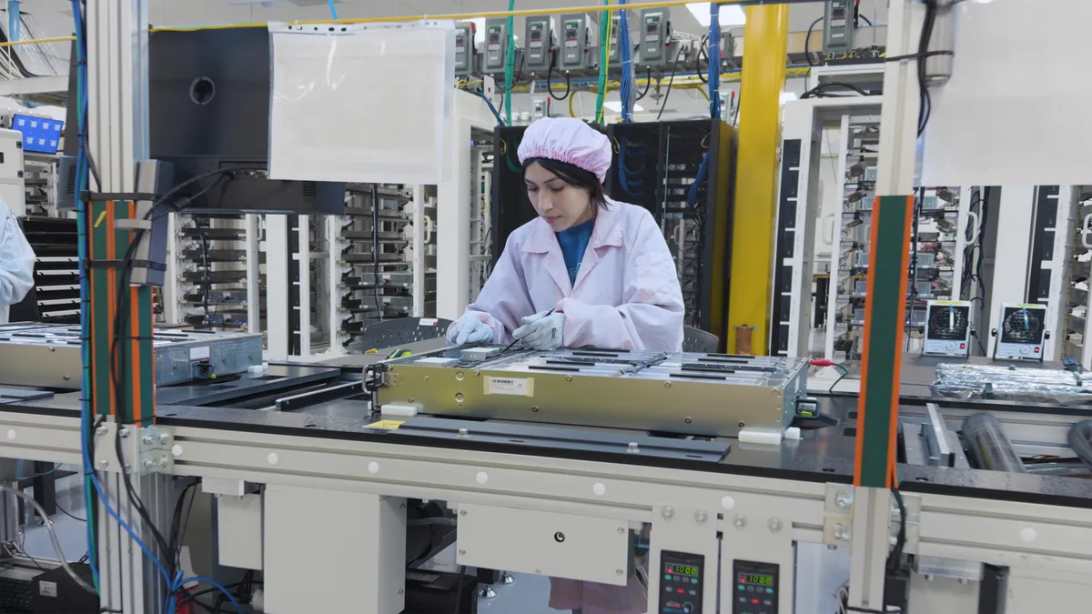 Angajată Apple asamblează componente pentru Mac mini în fabrica din Houston.