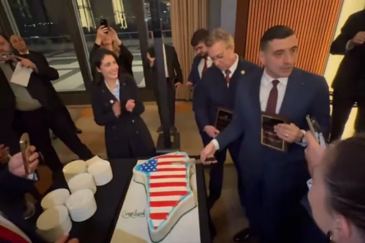 Oameni sărbătorind cu un tort în formă de hartă a SUA.