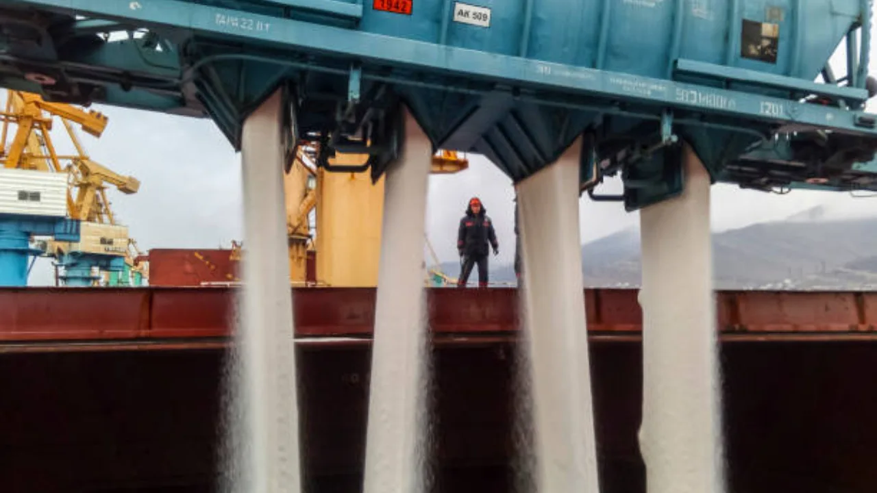 Fermier lucrând cu îngrășăminte într-un port, în contextul crizei agricole.