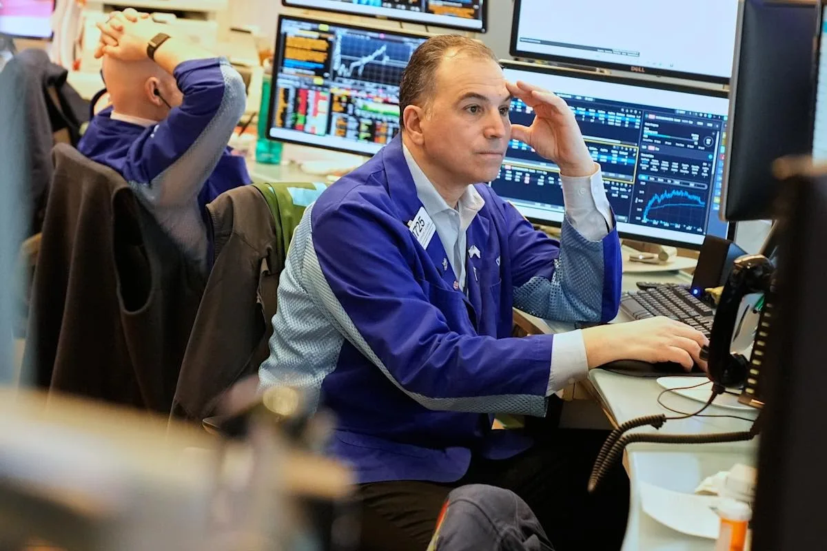 Investitor analizând date financiare pe un ecran de computer.