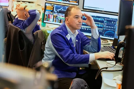 Investitor analizând date financiare pe un ecran de computer.