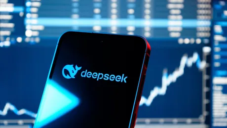Logo-ul DeepSeek pe un telefon, cu grafice financiare în fundal.
