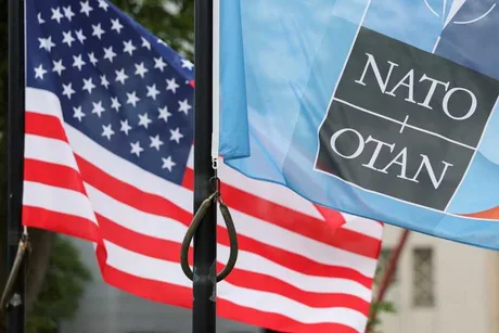 Steagurile NATO și ale Statelor Unite fluturând împreună într-o locație oficială.