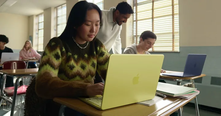 Studenți folosind laptopuri în clasă, concentrându-se pe studii.