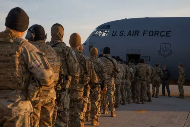 Soldați americani așteptând să se îmbarce pe un avion militar.