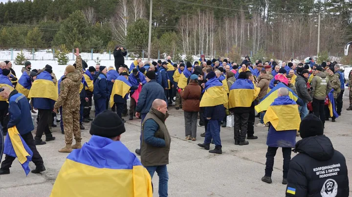 Oameni adunați pentru a sărbători un schimb de prizonieri în Ucraina.