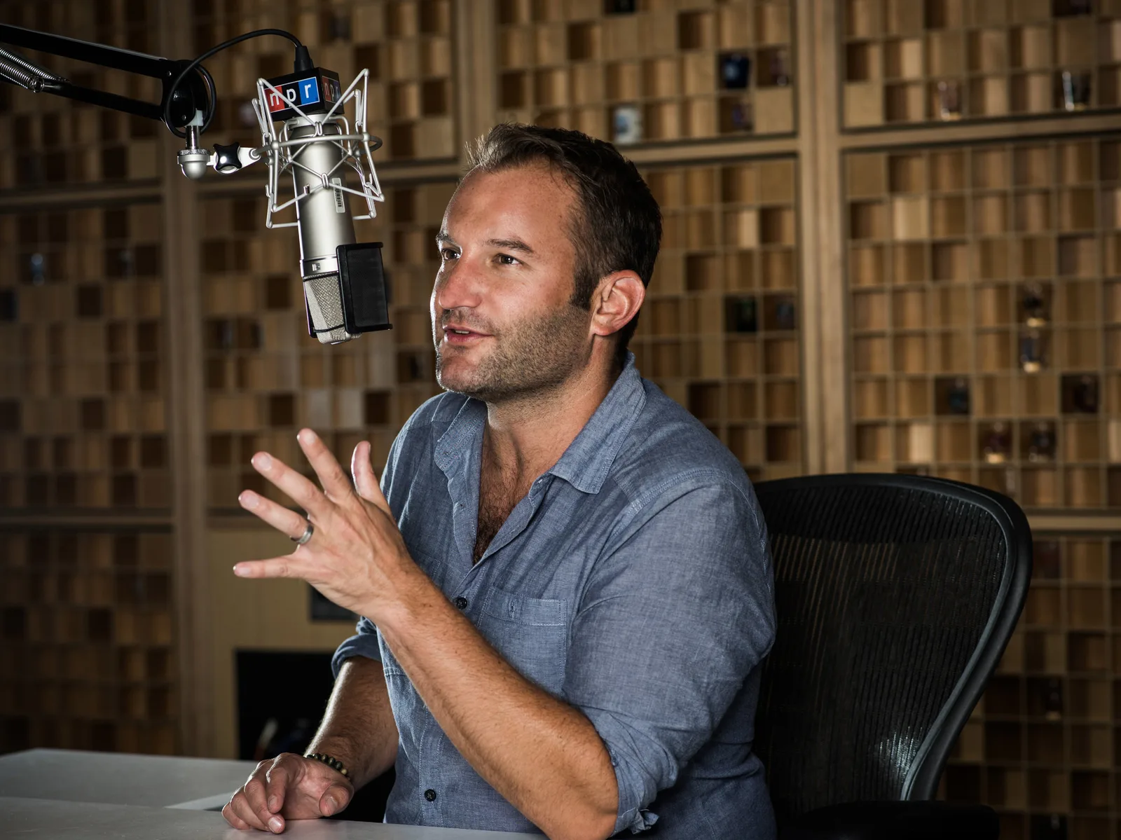 David Greene discutând la microfon într-un studio de înregistrare.