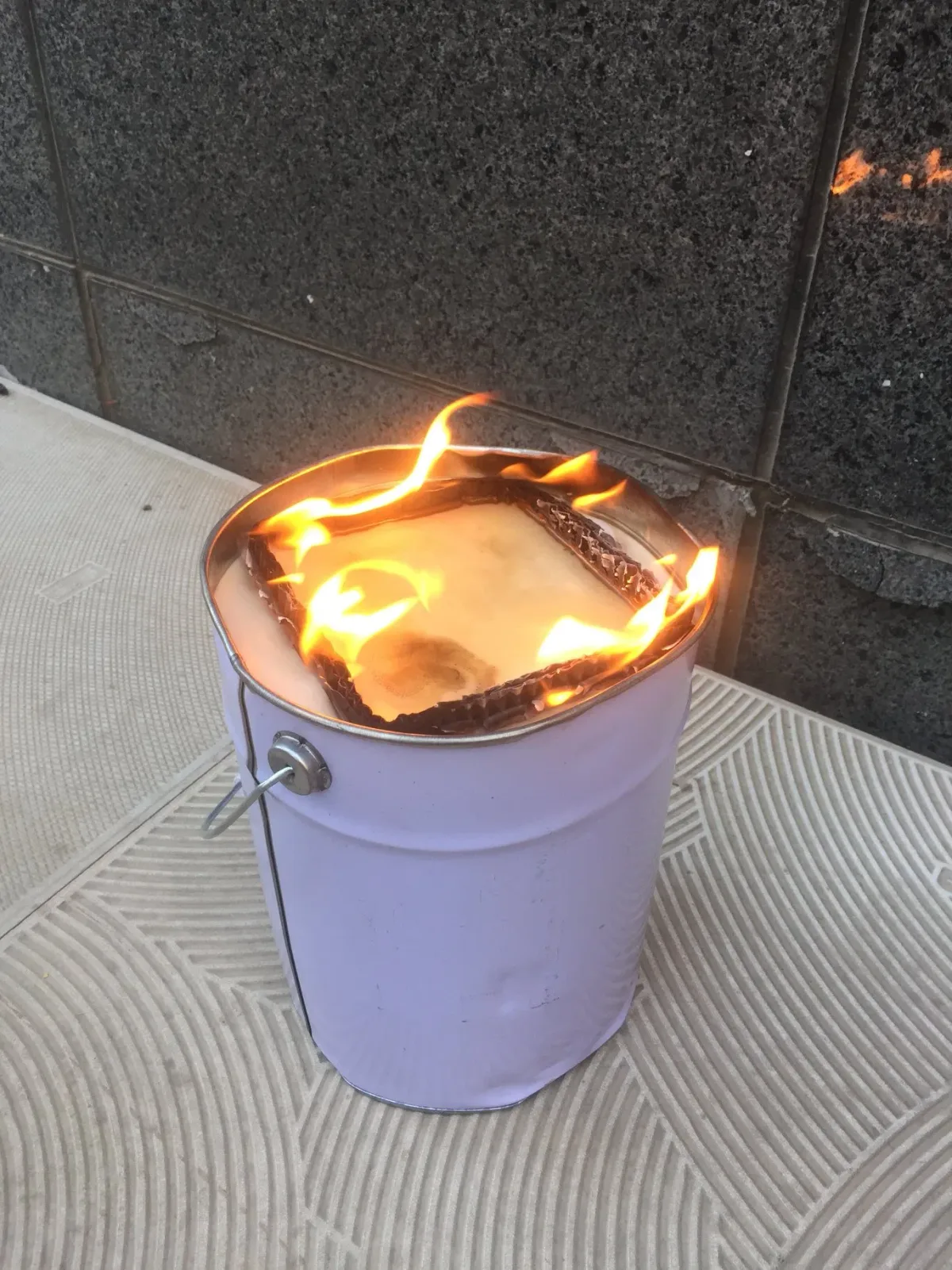 Lumânare aprinsă în recipient metalic pentru protecția viței-de-vie.