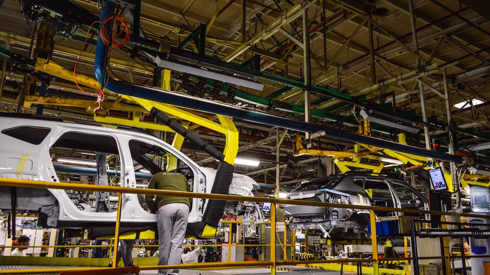 Linie de asamblare la fabrica Dacia din Mioveni, cu mașini în construcție.