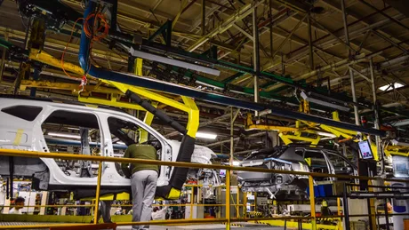 Linie de asamblare la fabrica Dacia din Mioveni, cu mașini în construcție.