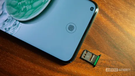 Un telefon mobil cu un slot pentru cartelă SIM pe o masă din lemn.