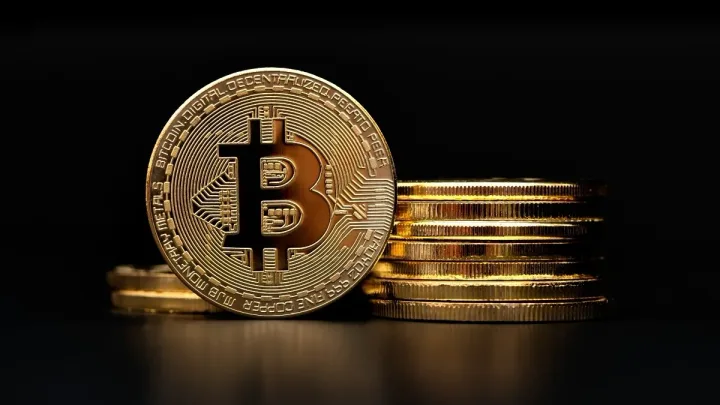 Monede Bitcoin stivuite pe un fundal întunecat, simbolizând volatilitatea pieței.