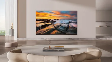 Televizor modern pe perete, cu un peisaj vibrant pe ecran.