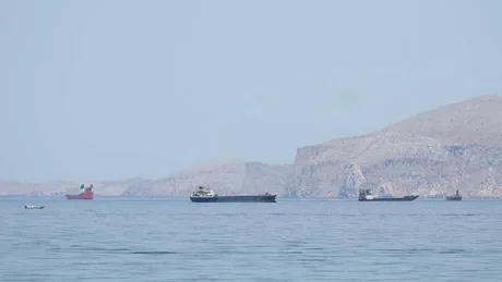 Vedere asupra Strâmtorii Ormuz cu nave comerciale ancorate.