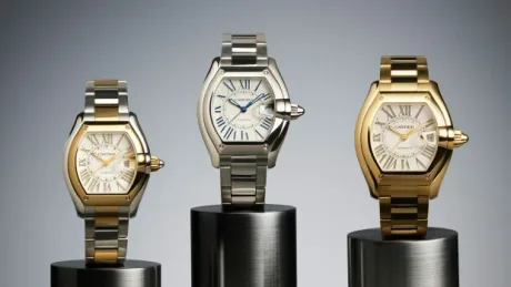 Trei modele de ceasuri Cartier pe suport metalic, cu design elegant și sofisticat.
