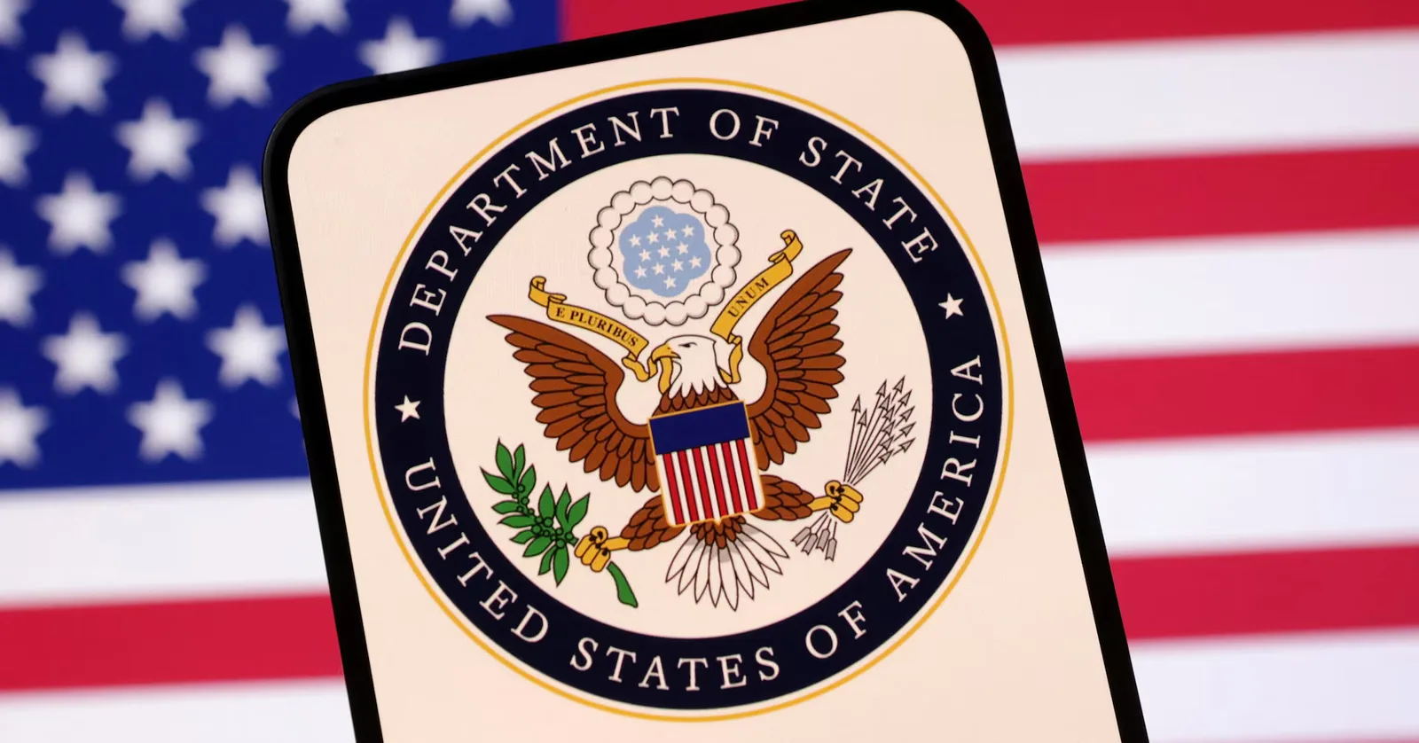 Sigla Departamentului de Stat al SUA pe fundal cu steagul american.