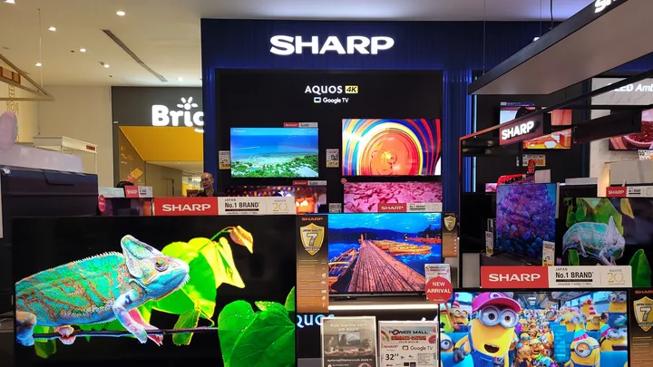 Stand de televizoare Sharp cu diverse modele expuse într-un magazin