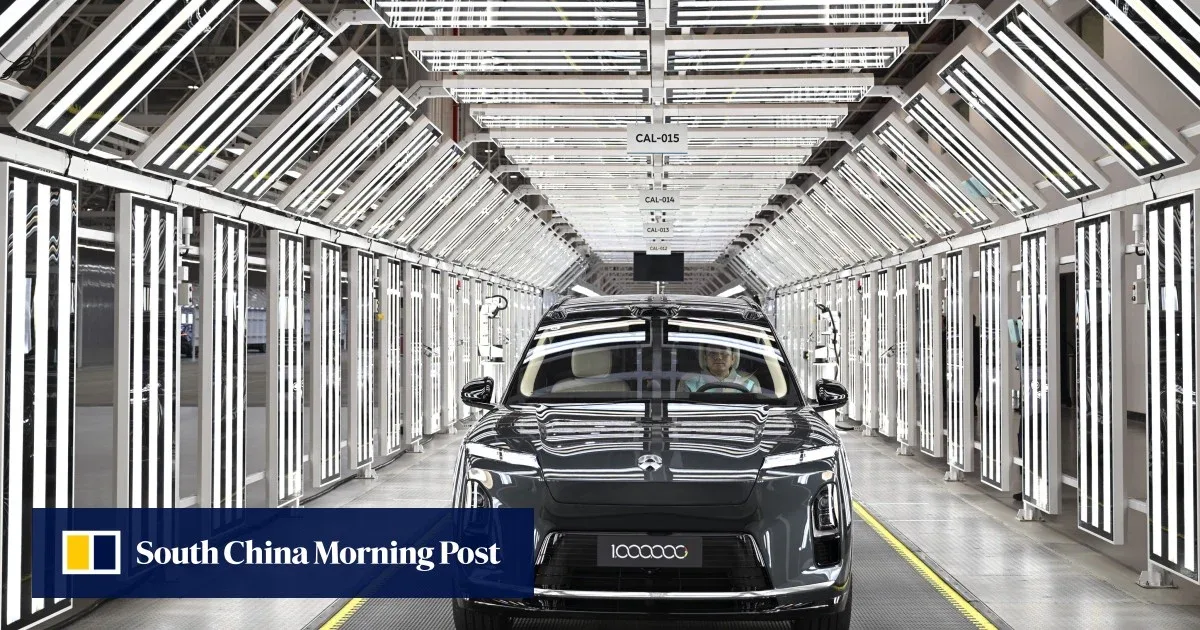 O mașină electrică într-o fabrică modernă, iluminată de linii de LED-uri.