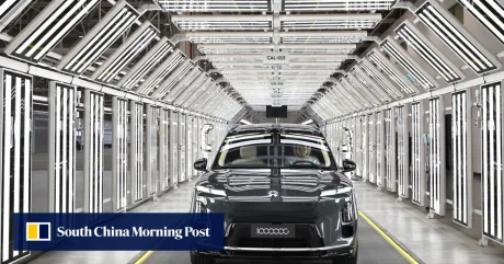 O mașină electrică într-o fabrică modernă, iluminată de linii de LED-uri.