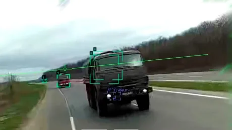 Dronă avansată cu inteligență artificială urmărind camioane pe un drum din estul Ucrainei.
