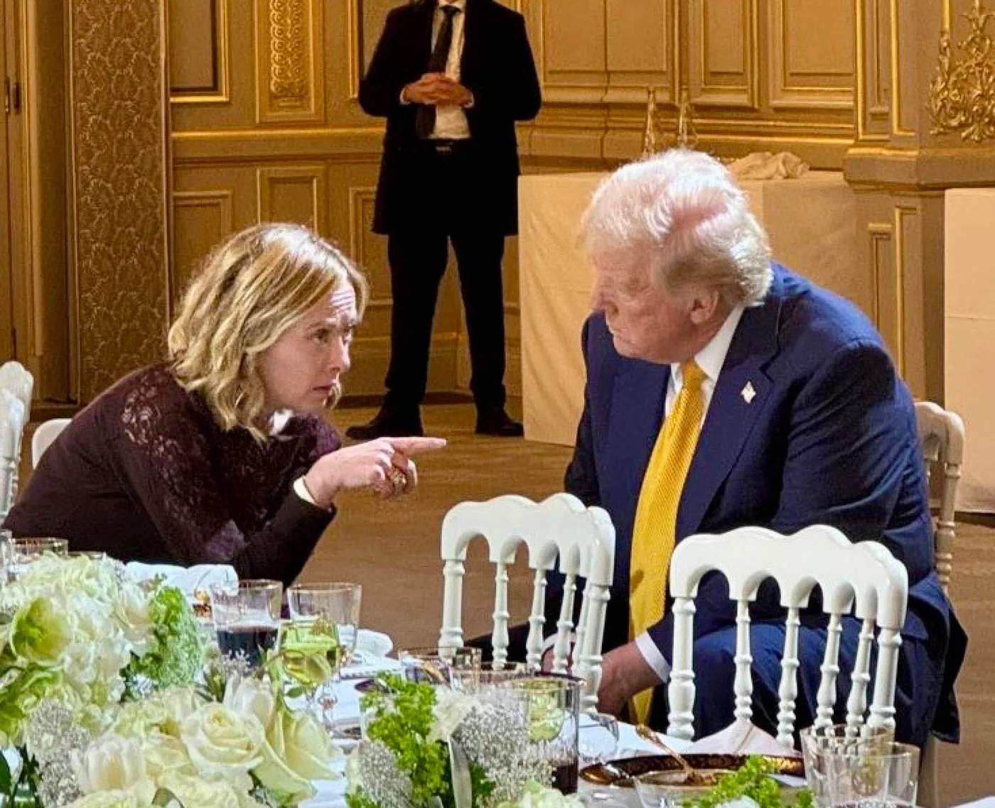 Giorgia Meloni discută cu Donald Trump la o masă elegantă.