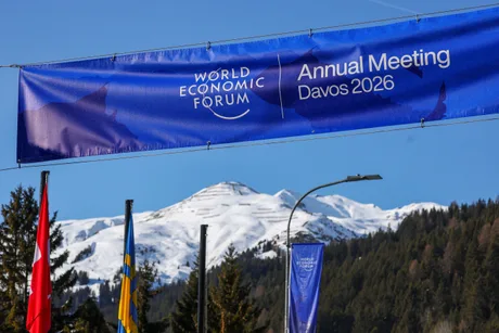 Banner al Forumului Economic Mondial la Davos, cu munți acoperiți de zăpadă în fundal.