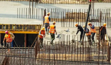 Muncitori români angajați în construcții, lucrând pe un șantier.