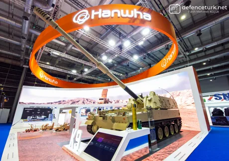 Standul Hanwha Aerospace cu vehiculul blindat K9 la un târg de apărare.