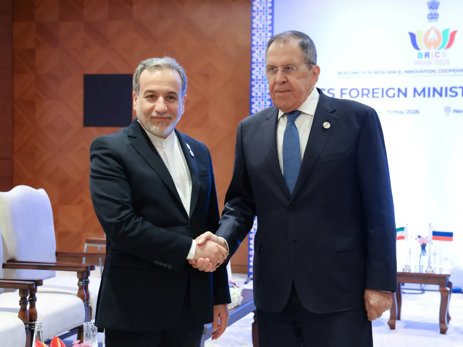 Miniștri de externe din Rusia și Iran se salută la o întâlnire oficială.