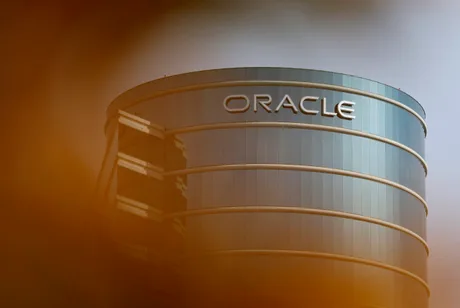 Clădire modernă cu logo-ul Oracle pe fațadă, reflectând cerul.
