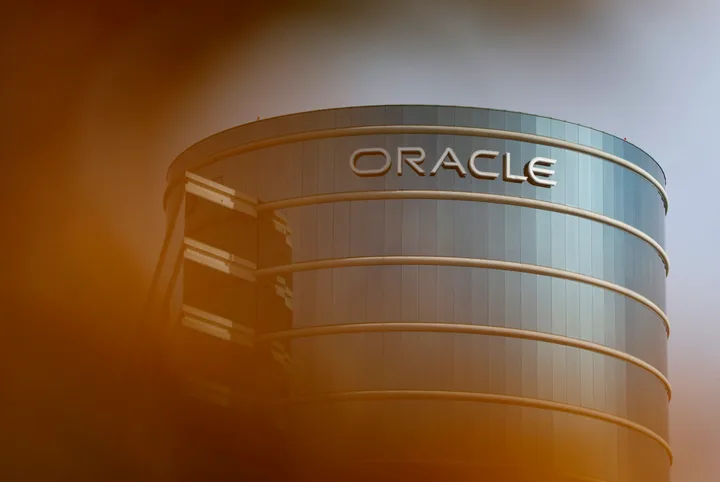 Clădire modernă cu logo-ul Oracle pe fațadă, reflectând cerul.