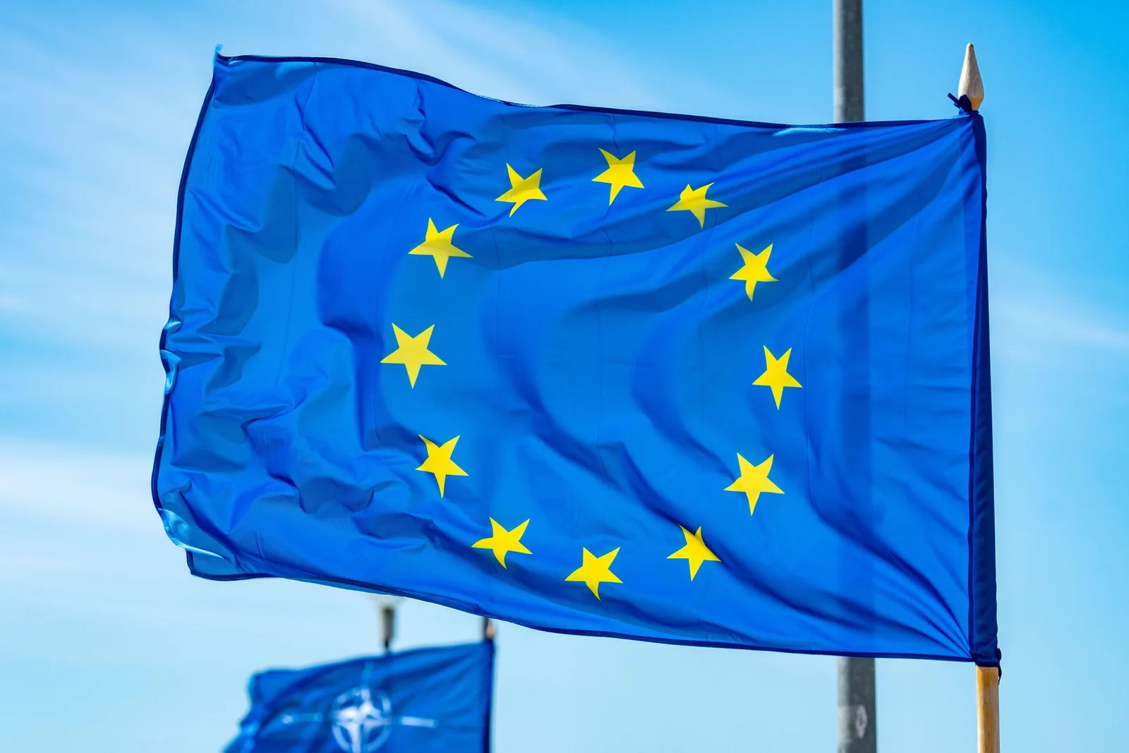 Steagul Uniunii Europene fluturând sub un cer senin.