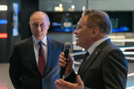 Vladimir Putin ascultând un oficial în timpul unei întâlniri importante.