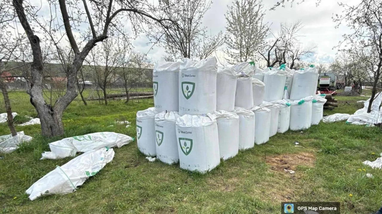 Îngrășăminte chimice depozitate necorespunzător pe o suprafață verde.