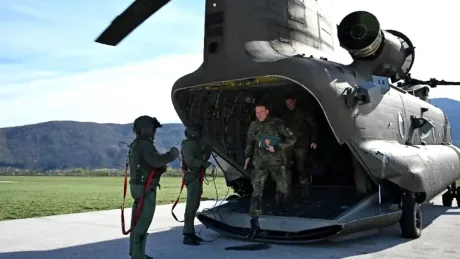 Soldați care se pregătesc să debarce dintr-un elicopter militar.