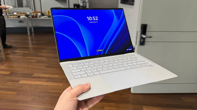 Laptopul ASUS ExpertBook Ultra expus pe un suport, cu ecran OLED 3K.