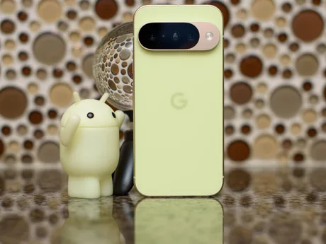 Un smartphone verde cu logo Google și figurina Android.