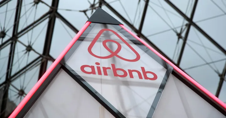 Logo-ul Airbnb pe un fundal modern, simbolizând inovația în turism.