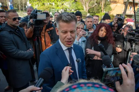 Peter Magyar discută cu jurnaliștii după alegeri, înconjurat de mulțime.