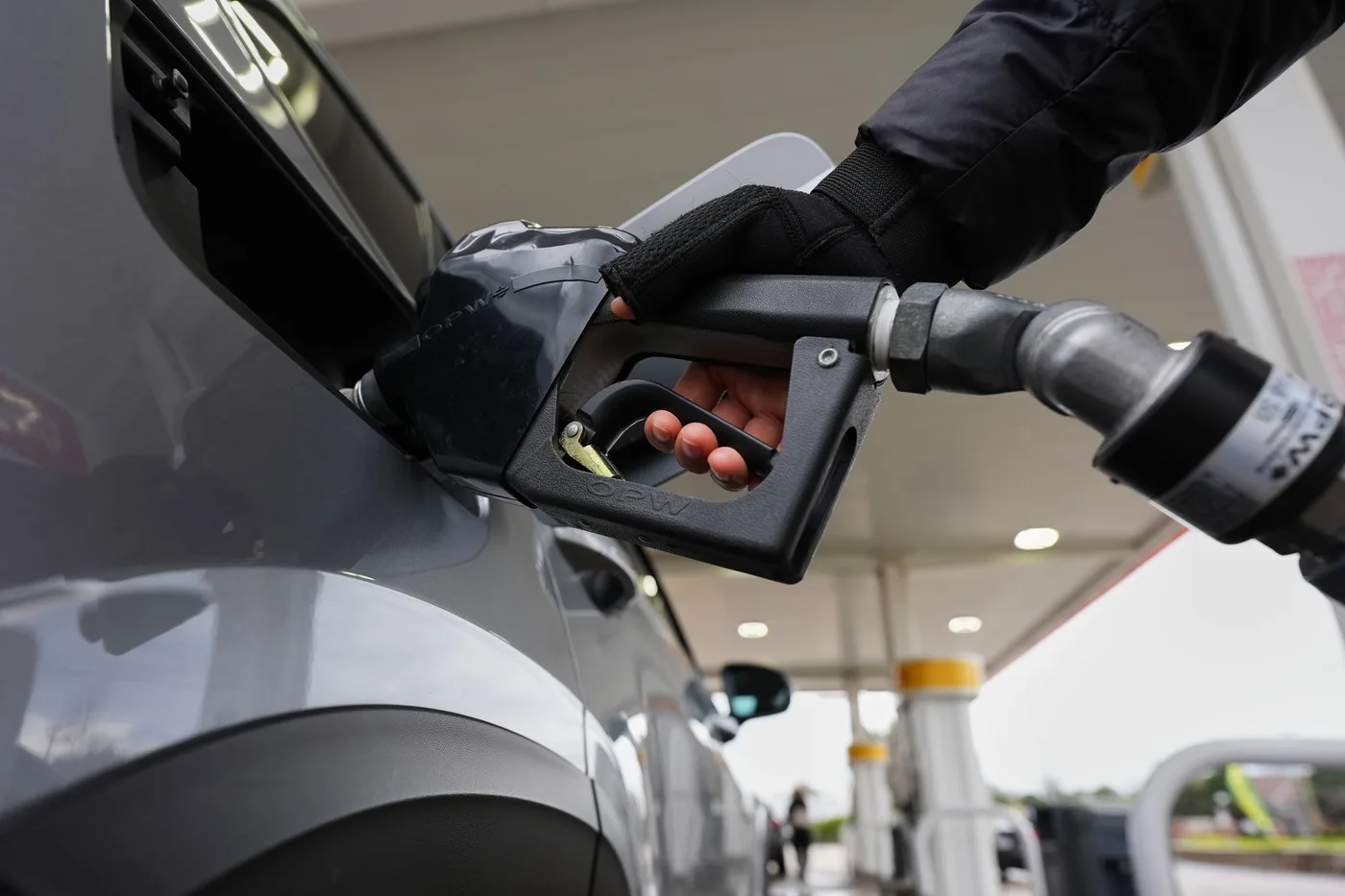 O persoană alimentează un vehicul la o stație de benzină.